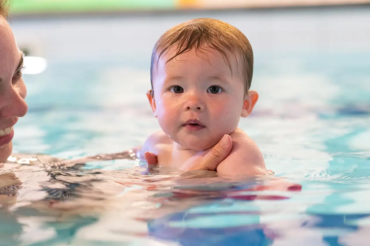Baby in het warme water van het zwembad