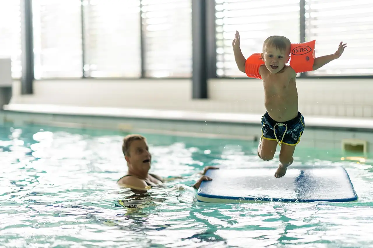 Peuter springt van de kant in het water
