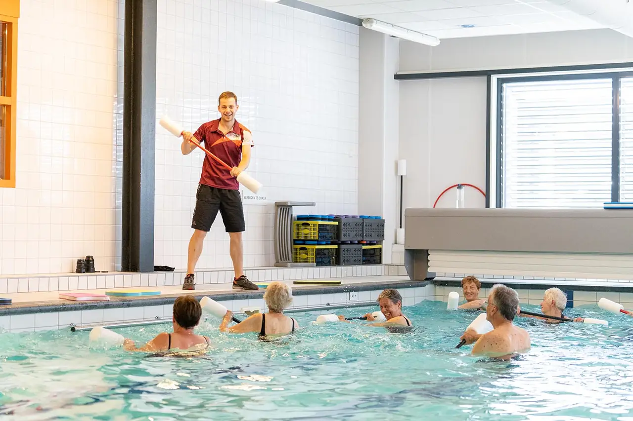 Instructeur aan de rand van het bad tijdens een waterles
